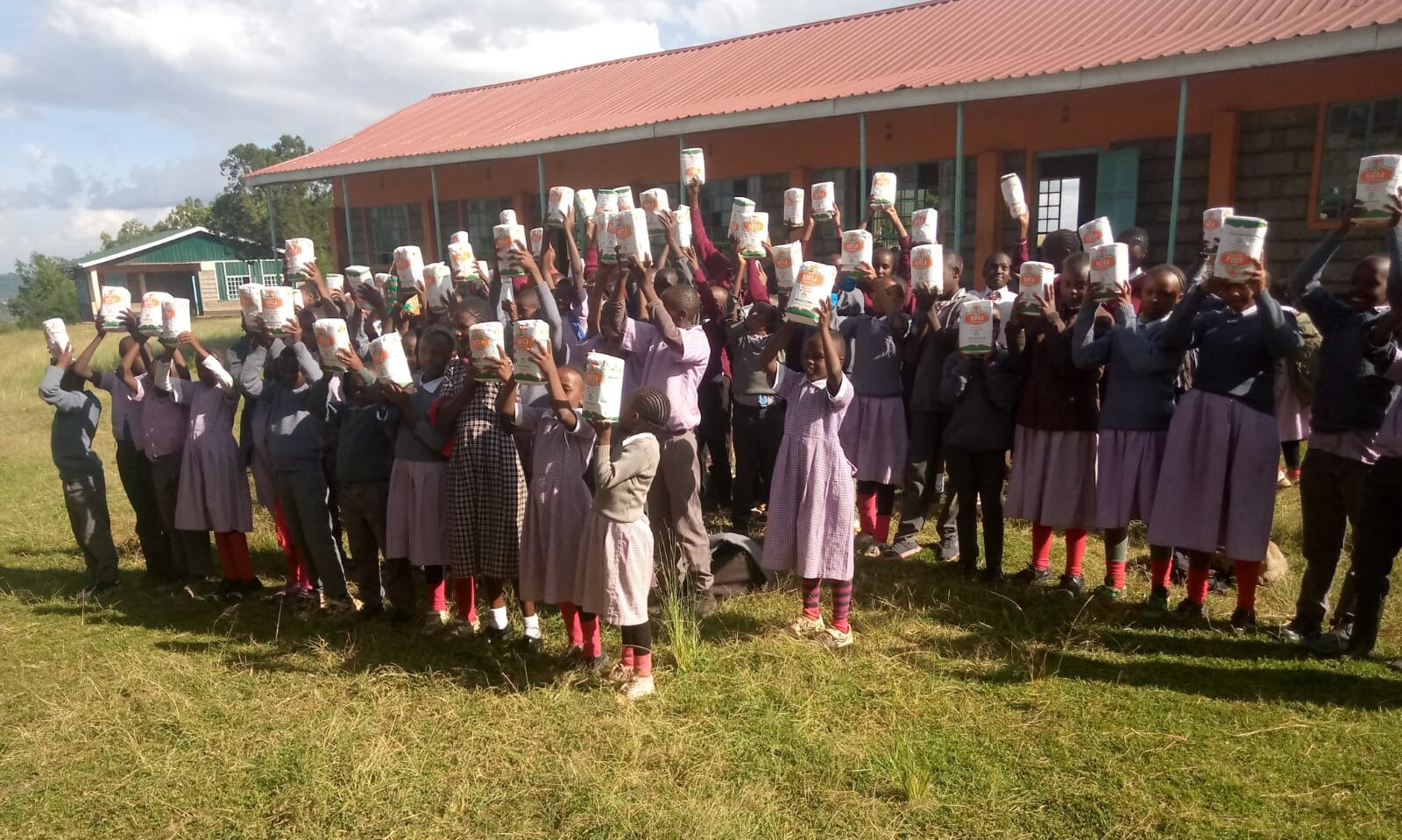 donating maize flour to school children